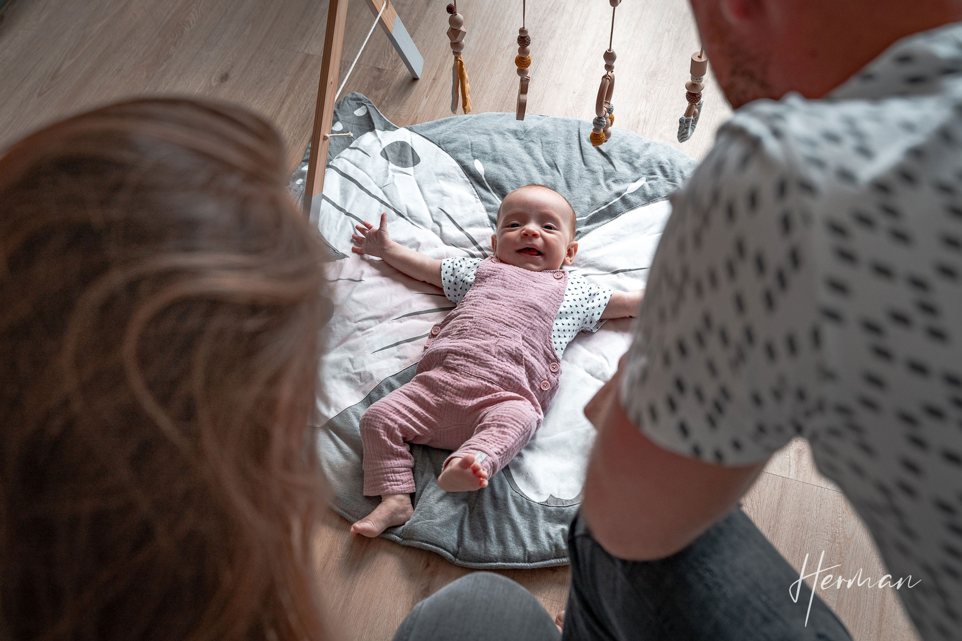 Lifestyle fotoshoot - Kind ligt op kleed en lacht - Herman Fotografie