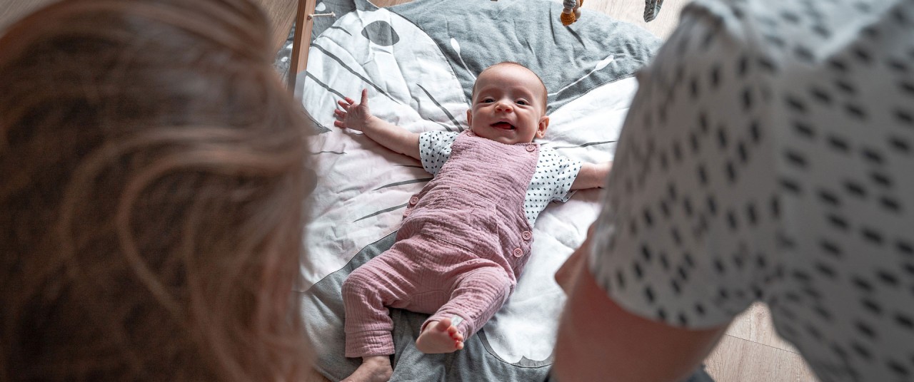 Lifestyle fotoshoot - Kind ligt op kleed en lacht - Herman Fotografie