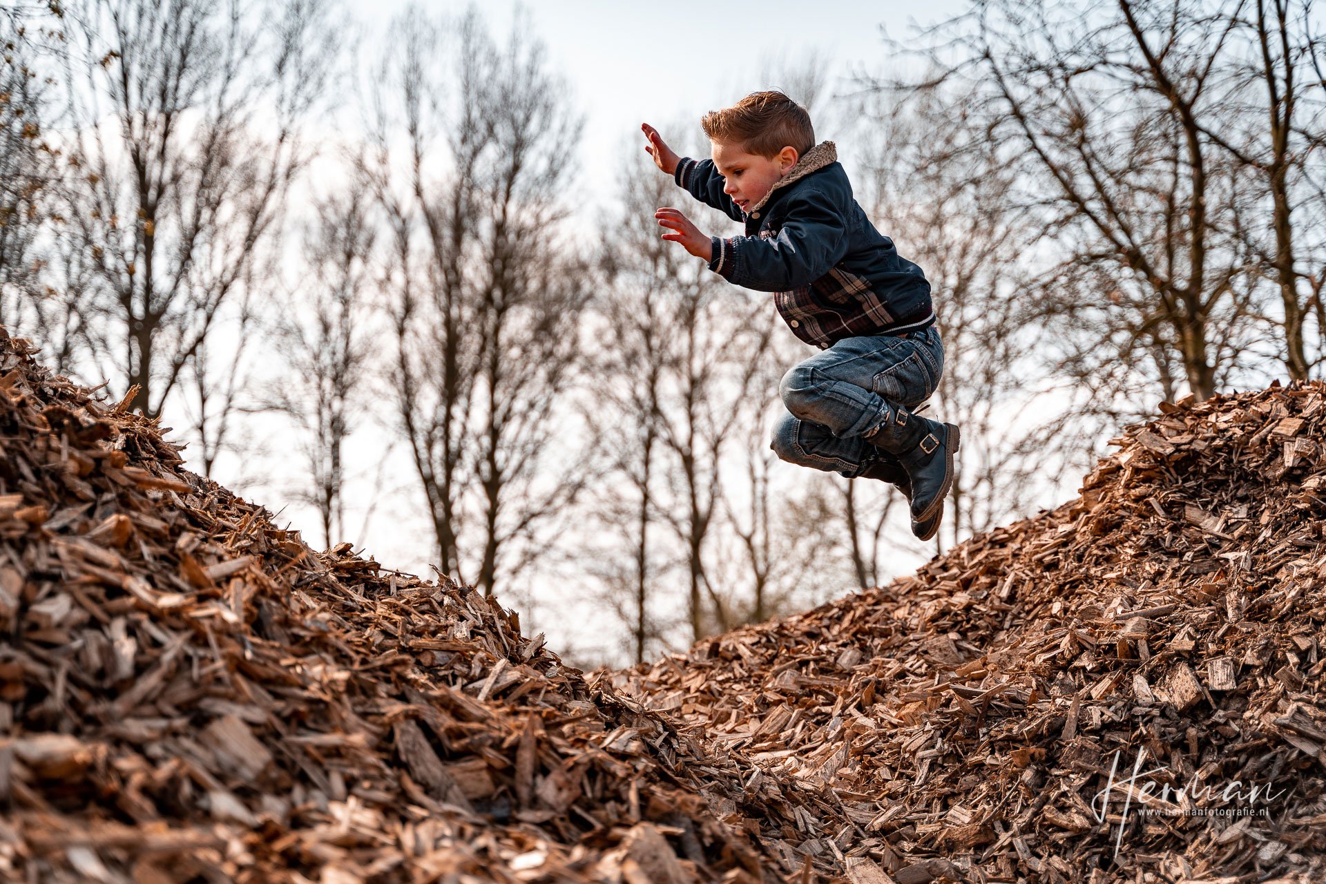 Lifestyle fotoshoot - Jongetje speelt in berg met houtsnippers in Rotterdam - Herman Fotografie