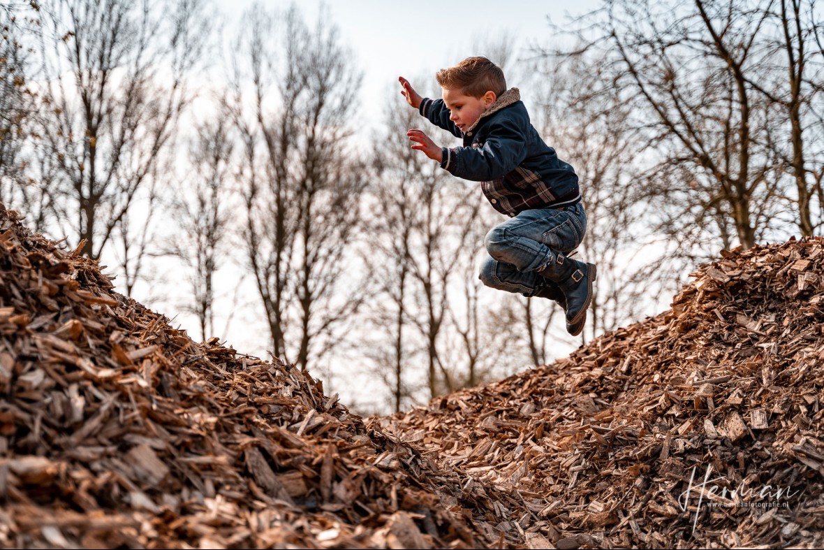 Lifestyle fotoshoot - Jongetje speelt in berg met houtsnippers in Rotterdam - Herman Fotografie