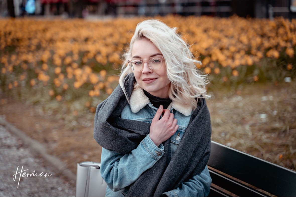 Polyna op een bankje voor een veld met narcissen in Den Haag - Portret fotoshoot in Den Haag