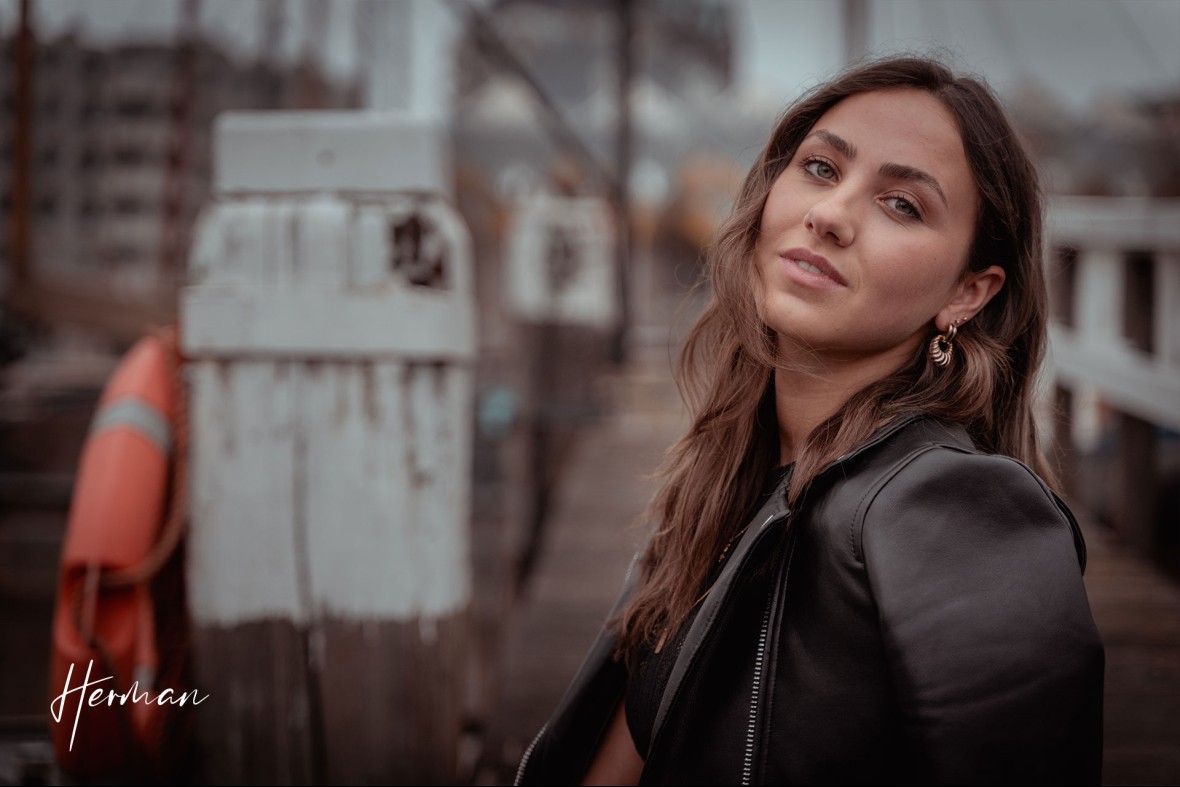 Roos kijkt in de camera op een steiger in de oude haven in Rotterdam - Portret fotoshoot in Rotterdam