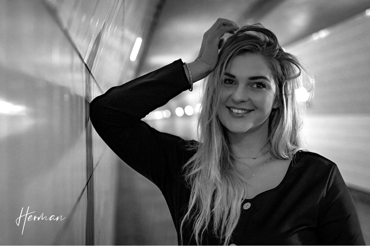 Klaartje lacht naar de camera in de Maastunnel in Rotterdam - Portret fotoshoot in Rotterdam